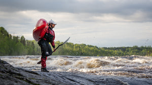 Whitewater kayaker, Benny Marr, in an Immersion Research dry suit by the river.