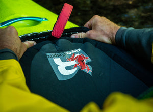 A whitewater, touring, our sea kayaking sprayskirt being put on a kayak.