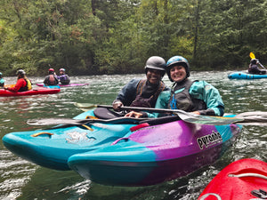 Two female kayakers smiling on the river