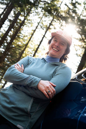 Person sitting outdoors with trees in the background