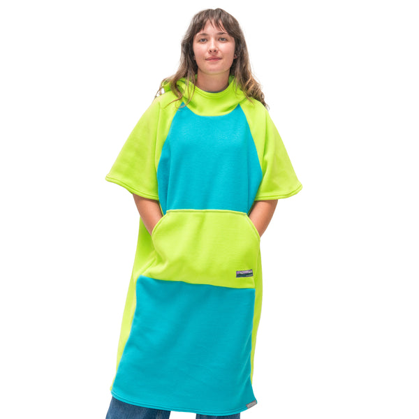 Person wearing a bright green and blue poncho on a white background