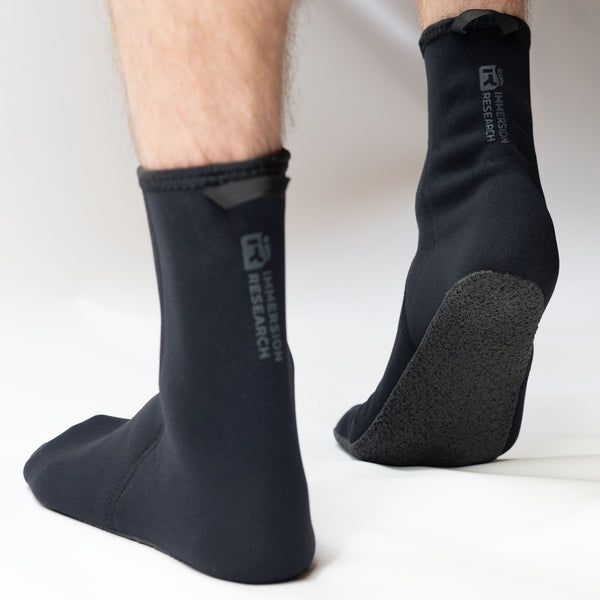 Black neoprene socks with grip on bottom of foot with brand logo on ankle on a white background
