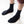 Black neoprene socks worn on feet against a white background