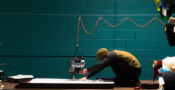 A product developer cutting fabric to sew outdoor gear made in the usa.