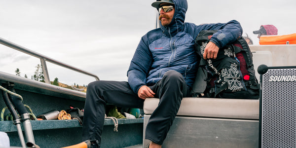 A man wearing Fancy Pants by Immersion Research riding on a boat.