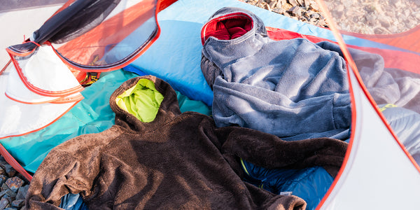 Two hot lap hoodies by Immersion Research laying in a tent.