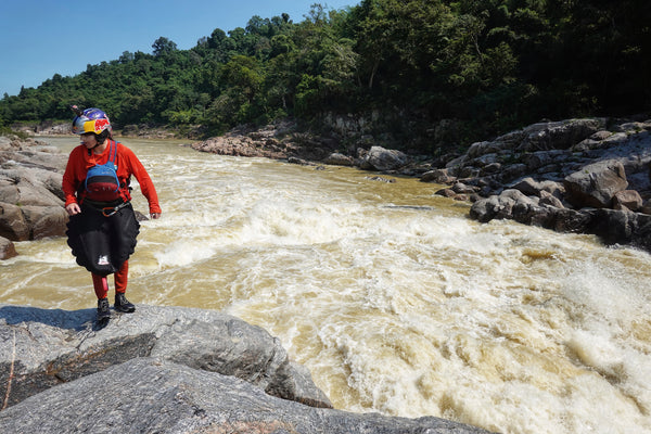 Nouria Newman, standing next to a rapid on a river in Nepal.