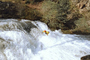 A Search and Rescue or Swift Water Rescue professional leaping into the river wearing an Immersion Research Dry Suit.