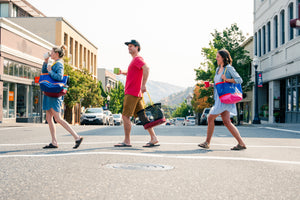 Three friends crossing the street with their totes from the Made in Hood River line by Immersion Research.