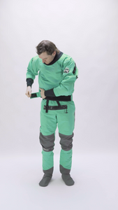 A man walks into the frame and tries on a Devils Club dry suit from Immersion Research to test the fit of the dry suit.