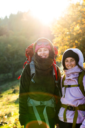 Two Girls wearing a hot lap hoodie from Immersion Research with hiking gear.